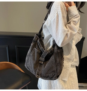 Close-up of vintage washed denim hobo bag with white contrast stitching and large pockets