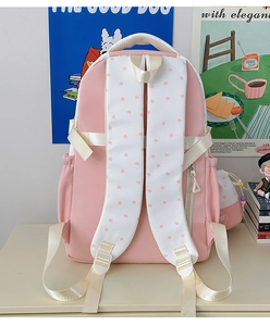 Detailed view of pink school backpack featuring star patterns and breathable mesh handle