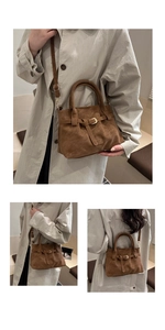 Detailed macro view of vintage brown suede tote bag with metallic buckle and shoulder strap