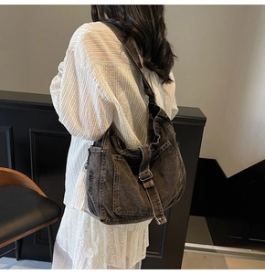 Detail of a large vintage-style washed canvas crossbody hobo bag with adjustable strap