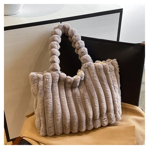 Detail of plush tote bag showing soft vertical stripes and unique beaded ball handle