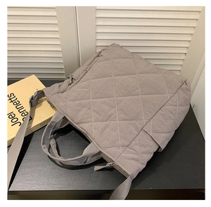 Detailed close-up of dark grey quilted nylon tote bag with rhombus pattern and wide straps