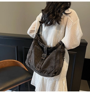 Detailed view of the vintage denim crossbody bag with multiple pockets and metal buckles