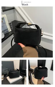 Détail d'un sac à main noir mat avec fermoir rotatif doré et large poignée élégante