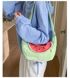 Close-up of green crossbody bag with pink watermelon slice design and embroidery