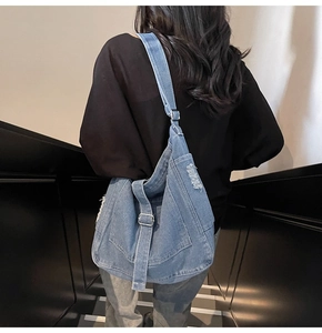 Detail of distressed denim tote bag with frayed holes and vintage street style texture