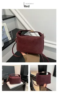 Détail du sac à bandoulière en cuir PU bordeaux avec élégant fermoir rotatif en métal doré