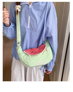 Close-up of a cute macaron green watermelon crossbody bag with pink embroidery and strap
