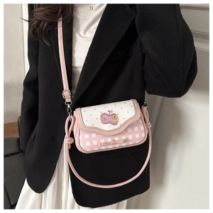 Detail of pink plaid crossbody bag with cherry embroidery and metal strap buckles