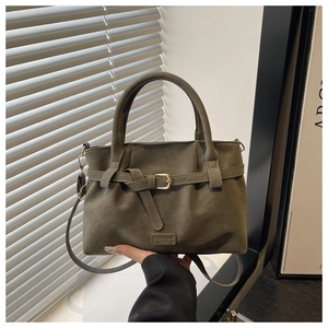 Detail of olive green suede tote with fashion embossed leather label and metal buckle