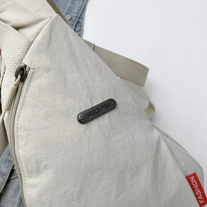 Minimalist cream white nylon chest bag for women with fashionable metal logo plate