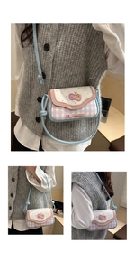 Detail of pink and blue plaid crossbody bag with bow and sweet fruit embroidery
