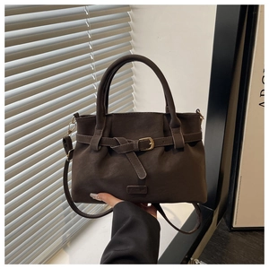 Detailed view of matte dark coffee suede tote with golden buckle and leather strap texture