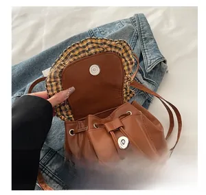 Détail du sac seau à cordon montrant la boucle magnétique et le rabat à carreaux