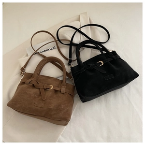Top view of vintage suede tote bags in brown and black with metallic buckle details
