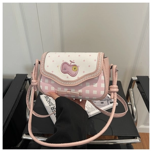 Detailed shot of pink and white patchwork crossbody bag with apple embroidery and bow decor