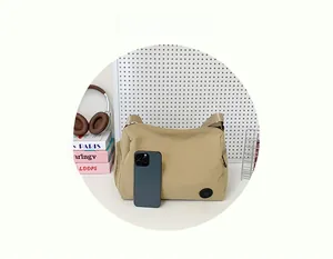Nylon bucket bag in khaki with a smartphone for size reference in a tidy setting
