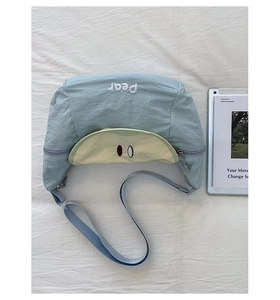 Detailed view of mint green crescent nylon crossbody bag with pear fruit embroidery