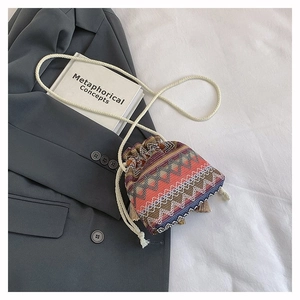 Detailaufnahme der Ethno-Beuteltasche mit bunten geometrischen Mustern und Quasten