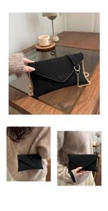 Detail of black textured envelope chain bag with fine glitter and gold metal strap