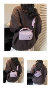 Detail of light purple nylon crossbody bag with adjustable strap and buckle closure