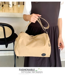 Detail of khaki nylon crescent bucket bag featuring an adjustable wide shoulder strap