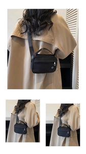 Detail showing back view of casual black nylon crossbody bag on a beige trench coat