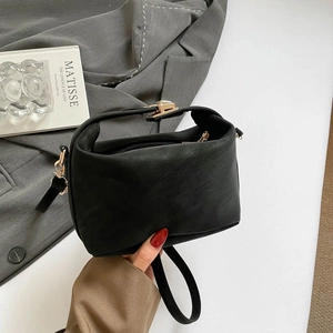 Sac Boston minimaliste en similicuir noir avec détails dorés et bandoulière