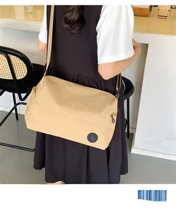 Detail showing high-quality khaki nylon fabric and adjustable strap of the crossbody bag