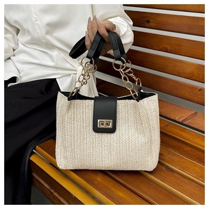 Detail of V-shaped straw weave pattern and elegant black leather handle with golden metal lock