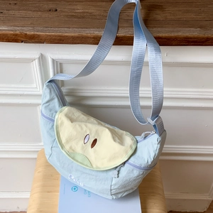 Light blue crescent canvas crossbody bag with pear fruit patch and adjustable strap