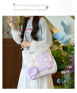 Vue détaillée du sac bandoulière en toile contrastée violet et blanc avec pochette fun