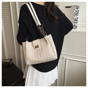 Detail of woven straw shoulder bag with leather trim and gold metal chain strap
