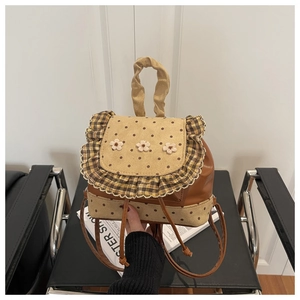 Détail du mini sac à dos floral avec rabat à pois et fleurs en tricot décoratives