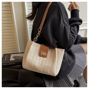 Chic woven straw tote bag with brown leather flap and gold chain strap for beach vacations