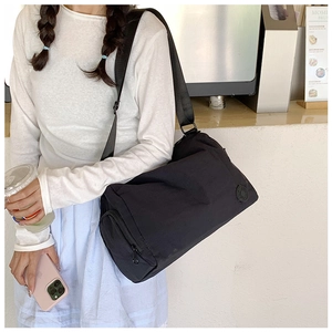 Detail of a large black nylon bucket bag with wide adjustable strap for daily commuting