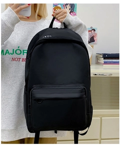 Close-up of minimalist black canvas backpack featuring printed white heart and sun icons