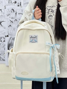 Detail of blue and white school backpack with ribbon and heart patch on a comic wall background