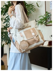 Détail du sac cabas en toile montrant les couleurs contrastées et la petite pochette