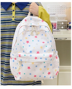 Detail shot of a white student backpack with colorful star patterns and sturdy zippers
