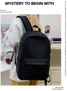 Side view of black minimalist canvas backpack with spacious main compartment on a student