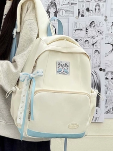 Detail of Korean style canvas backpack featuring blue lace bow and side pocket details