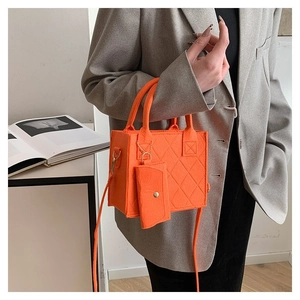 Detail der orangefarbenen gesteppten Filztasche mit Münzfach und Umhängeriemen