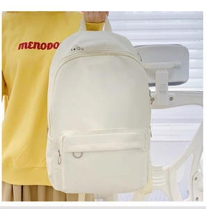 Close-up of off-white canvas backpack with star icons and silver D-ring detail