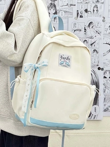 Detail of blue and white canvas backpack with decorative ribbon and heart pattern