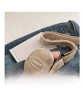 Close-up of beige corduroy small fashion bag with zipper showing interior for lipstick