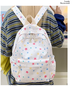 Close-up of a white star-patterned backpack with cotton rope zipper pulls and a front pocket