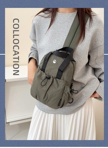 Detailed macro view of dark green nylon sling bag with elastic drawstring pocket and strap