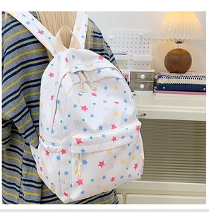 Close-up of white star pattern backpack with colorful print and rope zipper details