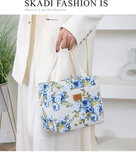 Detailed close-up of blue and yellow floral canvas lunch bag with leather logo patch